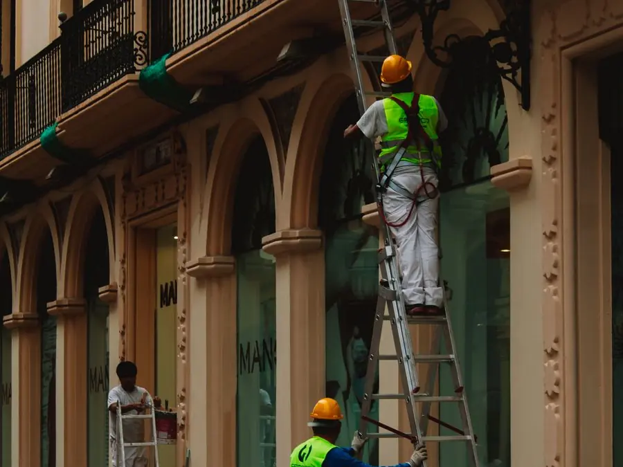 Ouvriers sur échafaudage rénovant la façade d'un immeuble